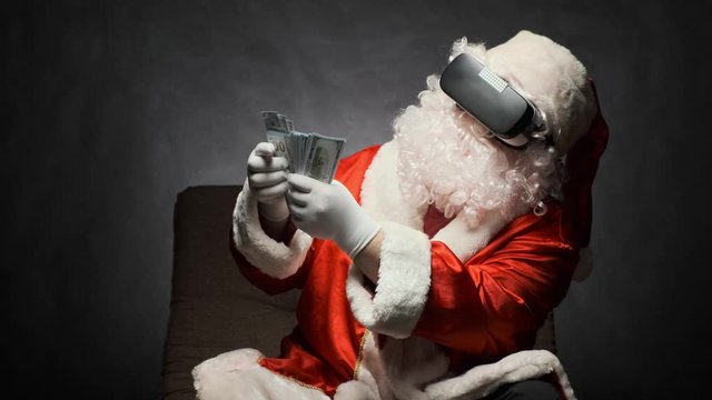 Santa Claus in glasses of virtual reality holds money in hands, flipping through them.