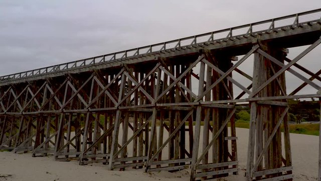 Drone Panning of Pudding Creek Trestle, Front Bragg, California. Panoramic view of historical bridge on sand beach.