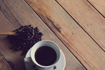 Coffee cup with coffee beans on wooden table