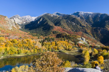 Lower Bells Canyon Reservoir in the backdrop of snowcapped Wasatch Mountains in peak fall season