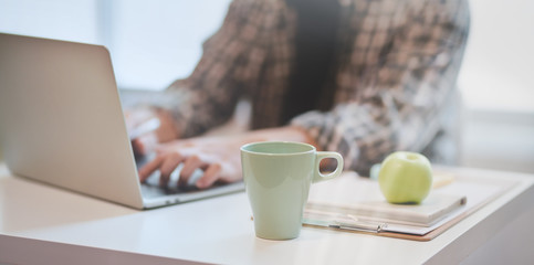 Designer working on his project while typing on laptop
