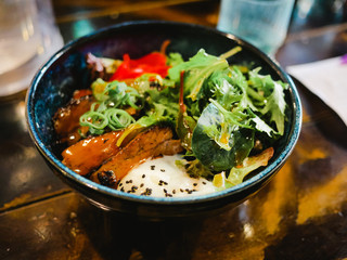 Japanese ramen with spoiled egg and fried pork and vegetables bowl inside restaurant
