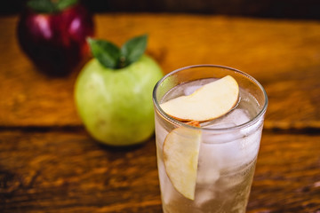 Apple spritzer (apfelschorle) pitcher, Glass pitcher of homemade spritzer served with crushed ice and apple slices. Jug full of non-alcoholic sparkling and cold carbonated apple juice.