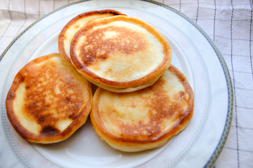 Cottage cheese pancakes on a plate, called syrniki. Traditional breakfast and dessert of Russia, Ukraine, Belarus and CIS countries. 