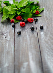 On a wooden background, fresh leaves of currant, raspberry and currant.