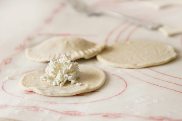 Perogies (varenyky) being prepared with dry cottage cheese and pinched together with fork; cooking varenyky from scratch and stuffing the pockets with cheese
