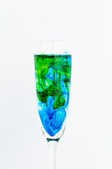 Diffusion of green and blue ink in water in transparent glass.CR2