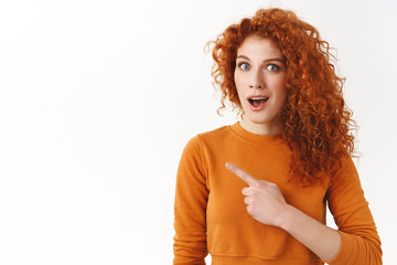 Excited curious redhead curly-haired gorgeous woman looking questioned, open mouth gasping...