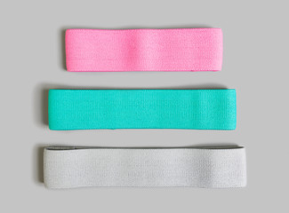Resistance loop exercise bands in three various colors and sizes isolated on gray background