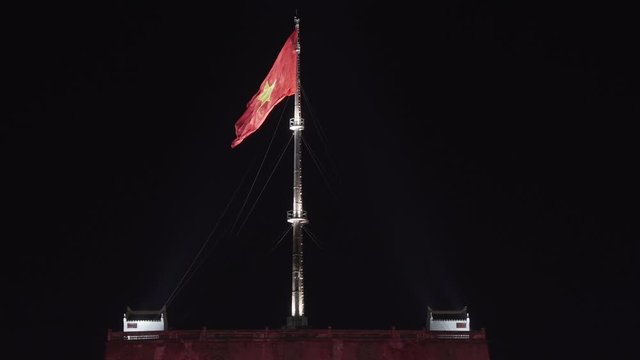 Vietnam Flag blow in the wind of Imperial city entrance, Hue. Vietnamese national flagship over fly nighttime over a fortress nighttime.