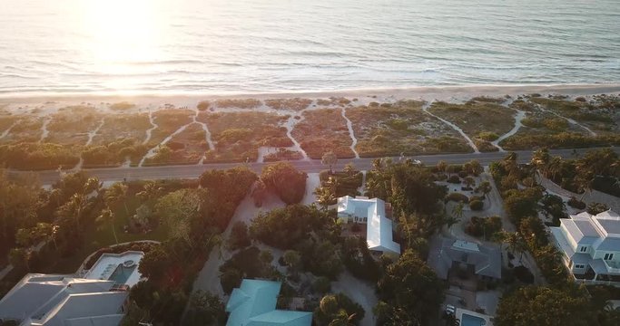 Aerial drone shot of villas overlooking the beach on Captiva Island, Florida, at sunset.