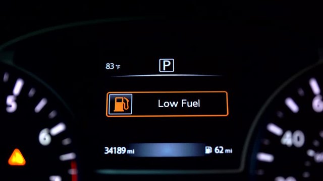 Low fuel warning on car dashboard