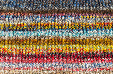 background of bright multi color striped fabric knitted by the hand