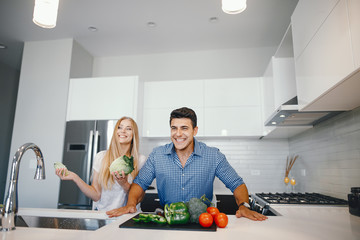 Man in a kitchen. A handsome man with woman at home. Male and famale at home with vagatables....