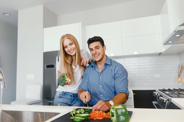 Man in a kitchen. A handsome man with woman at home. Male and famale at home with vagatables....