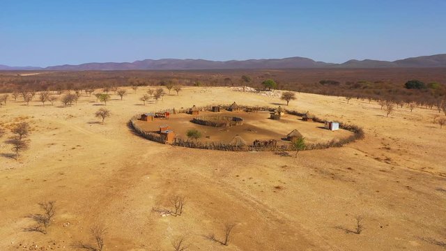 Beautiful aerial over a round Himba African tribal settlement and family compound in northern Namibia, Africa.