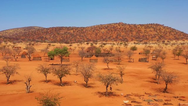 Low aerial over a Himba African tribal settlement and family compound in northern Namibia, Africa.