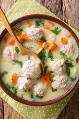 Traditional soup with meatballs, yogurt and vegetables close-up in a bowl. Vertical top view