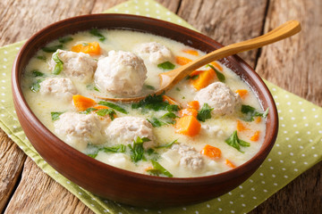 Traditional soup with meatballs, yogurt and vegetables close-up in a bowl. horizontal