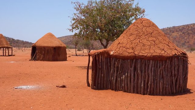 Small poor African Himba rural village on the Namibia Angola border with mud huts, goats and children.