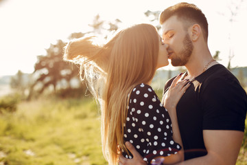 Cute couple in a park. Lady in a black dress. Guy in a black t-shirt.