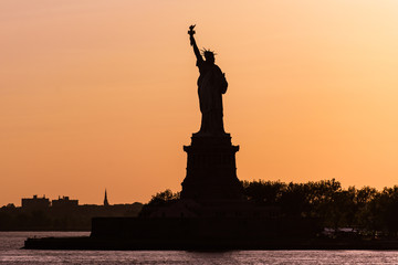 Fototapeta premium Vista a contraluz de la estatua de la libertad al anochecer
