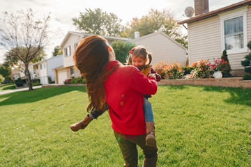Cute family in a autumn park. Happy mother with little daudhter. Family in the courtyard near the house.
