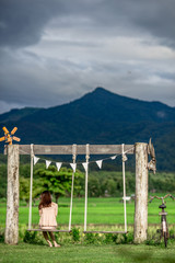 The background of young women, tourists who come to see the scenery along the rice fields and have a large mountain surrounded, happiness during travel