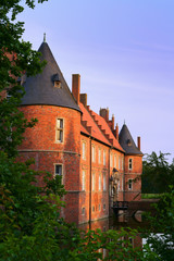 Romantic Herten castle, illuminated by the evening sun in August. Moated castle, Ruhr area in North...