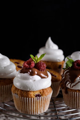 Delicious flavored cupcake with raspberries, white cream, and chocolate icing.