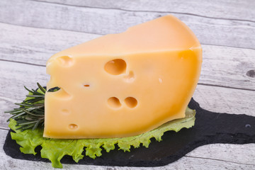 Maasdam cheese  in the board served salad leaves