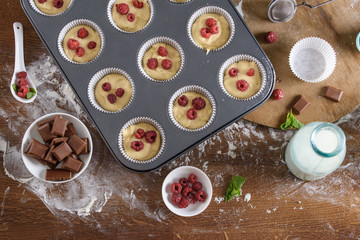 Delicious flavored cupcake with raspberries, white cream, and chocolate icing.