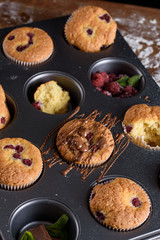 Delicious flavored cupcake with raspberries, white cream, and chocolate icing.