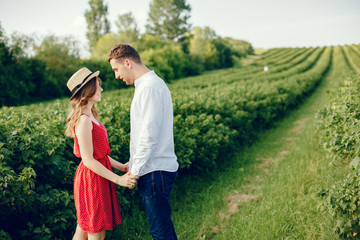 Couple in a field. Girl in a red dress. Man in a white shirt