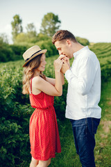 Couple in a field. Girl in a red dress. Man in a white shirt