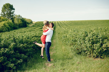 Couple in a field. Girl in a red dress. Man in a white shirt