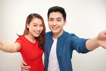 Obraz premium Young couple take selfie on white background