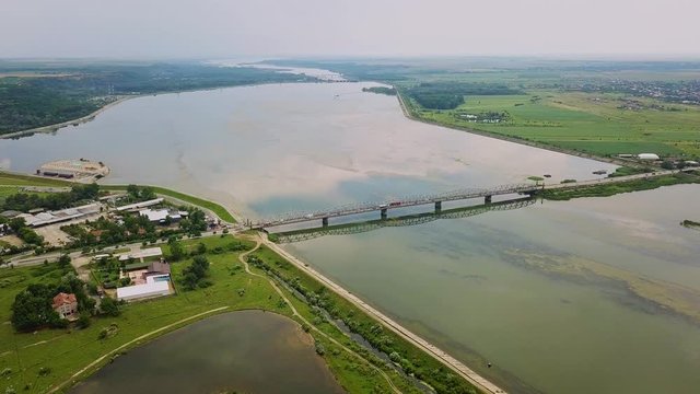 Aerial Drone Flight: View of the bridge over the river with cars. Olt river, Romania