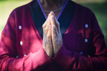 The old woman closed hand is prayer and thank God.
