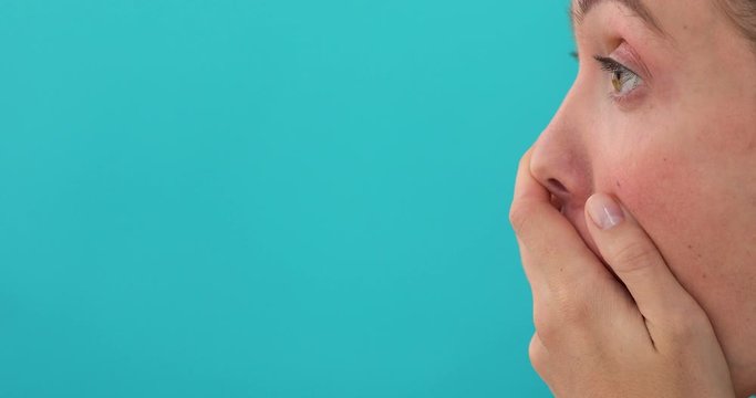 Young shocked surprised woman isolated over blue background while looking away