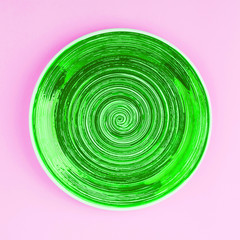 Saturated green plate on the light pink background