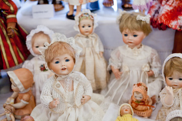 antique porcelain doll in vintage dresses in a blurred light
