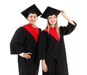 Young students in bachelor robes on white background