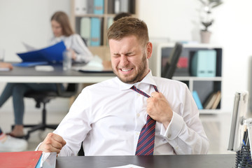 Businessman having panic attack in office