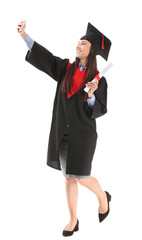 Female graduate taking selfie with diploma on white background