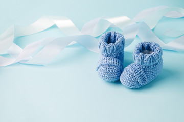 Fototapeta Blue Baby knitted shoes for newborns on blue background, Minimal baby shower, newborn party background, copy space obraz