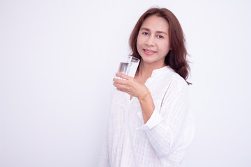 Happy young woman showing drinking glass with water at home.