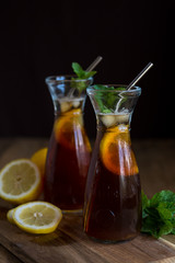 Lemon and mint iced tea in glass carafes
