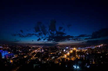 Amazing view on the night city lights and dark blue sky above, cityscape