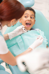 Boy opening mouth while having dental examination